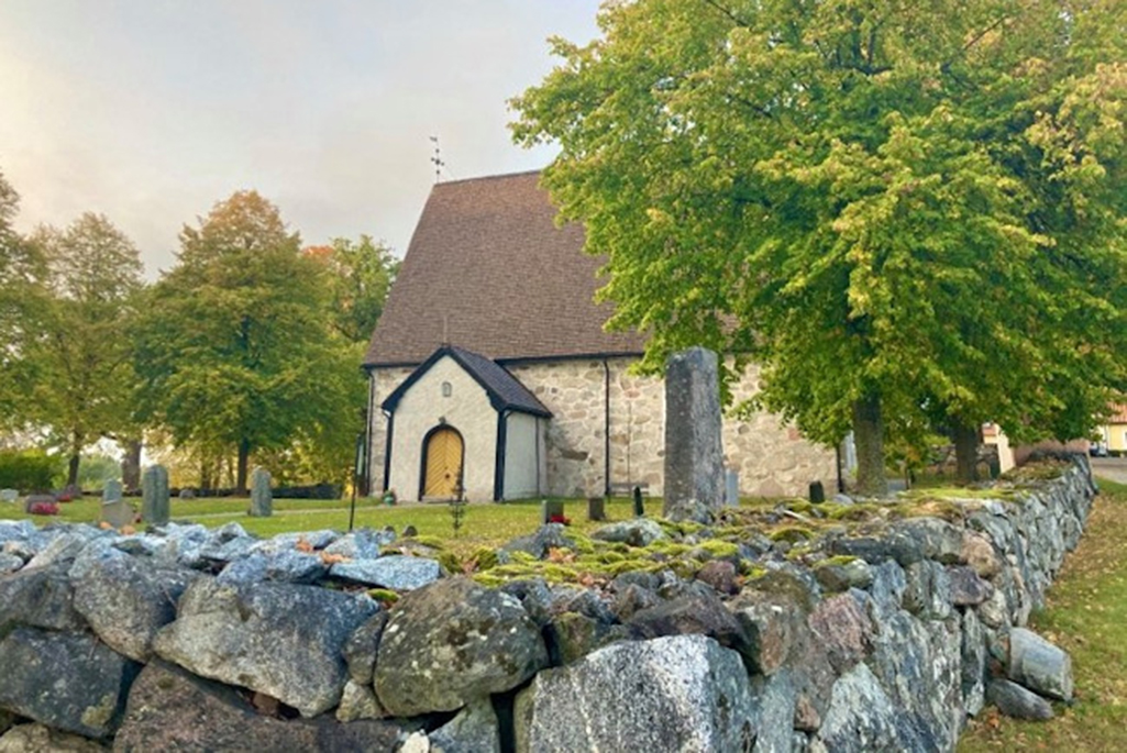 Bild på Torsvi kyrka. En stenbyggnad med tydliga stenar i väggarna.